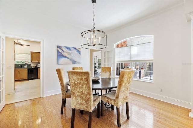 dining space with crown molding, a notable chandelier, and light hardwood / wood-style flooring