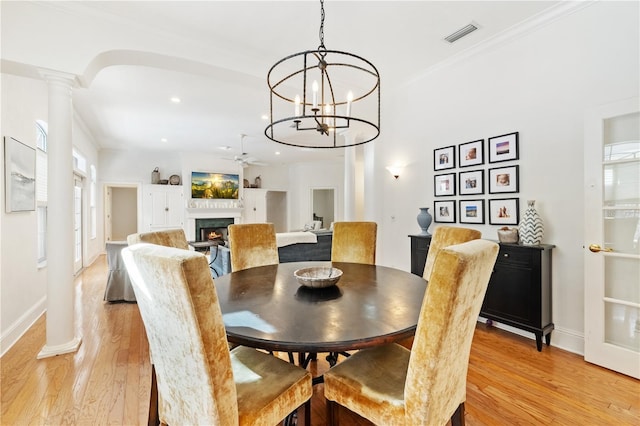 dining area with ceiling fan, ornamental molding, decorative columns, and light wood-type flooring