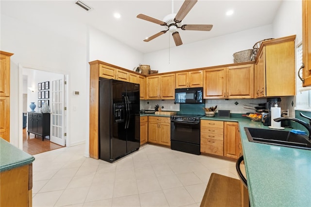 kitchen with sink, black appliances, ceiling fan, a high ceiling, and backsplash