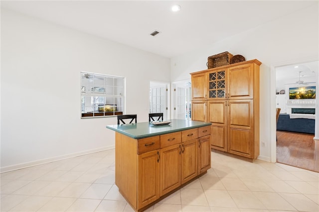 kitchen featuring ceiling fan, a kitchen island, and light tile patterned floors