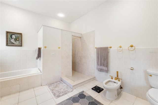 bathroom featuring a bidet, tile walls, a relaxing tiled tub, tile patterned floors, and toilet