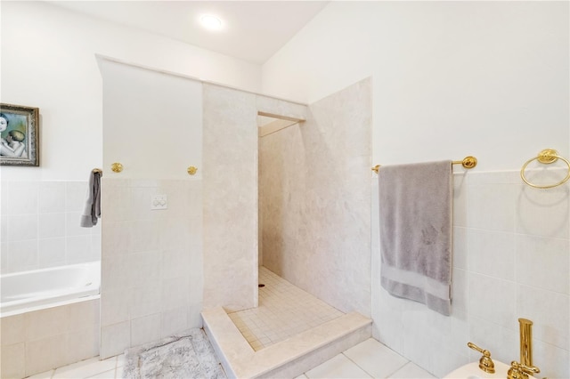 bathroom featuring a bidet, tile patterned flooring, tile walls, and a tile shower