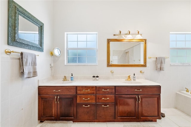 bathroom featuring tile patterned flooring, vanity, tile walls, and a tub to relax in