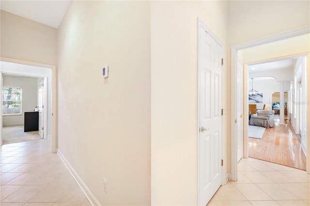 hall featuring light tile patterned floors and a high ceiling