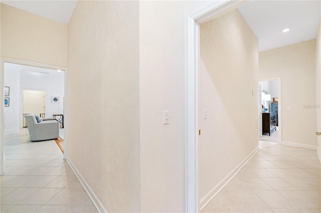 hall featuring a high ceiling and light tile patterned floors