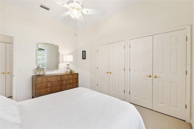 bedroom featuring ceiling fan and two closets