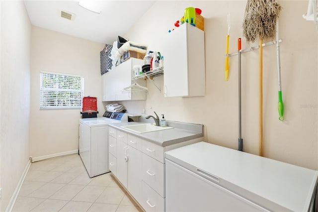 clothes washing area featuring cabinets, sink, washing machine and dryer, and light tile patterned floors