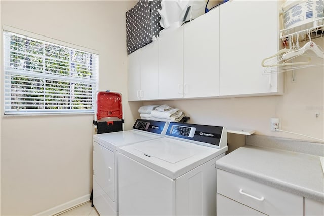 clothes washing area featuring independent washer and dryer and cabinets