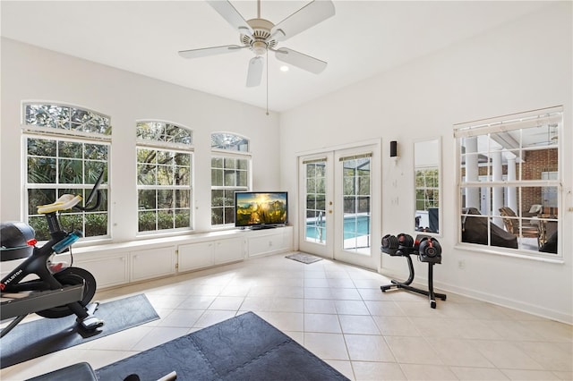 exercise area with light tile patterned floors, french doors, and ceiling fan