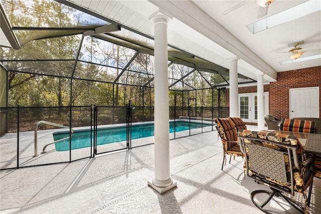 exterior space featuring french doors, ceiling fan, glass enclosure, and a patio