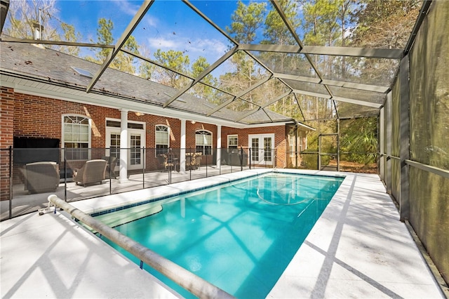 view of swimming pool featuring a patio, french doors, and glass enclosure