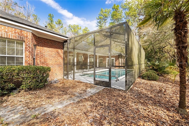 view of swimming pool featuring a lanai and a patio