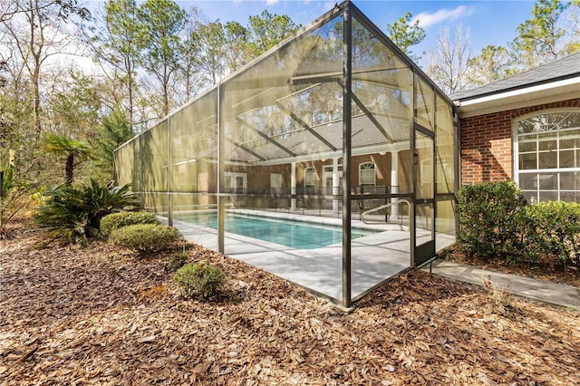 view of swimming pool featuring a patio and glass enclosure