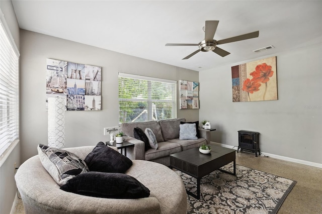 living room with ceiling fan and a wood stove