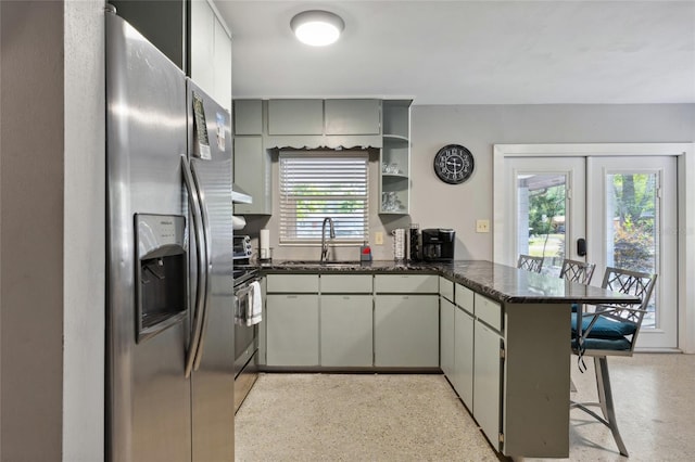 kitchen with sink, a kitchen bar, kitchen peninsula, stainless steel appliances, and french doors