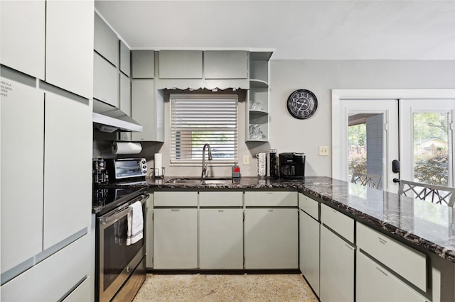 kitchen with electric stove, dark stone counters, sink, and plenty of natural light