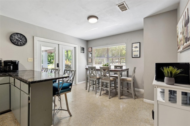 kitchen featuring french doors, a breakfast bar area, a wealth of natural light, and kitchen peninsula