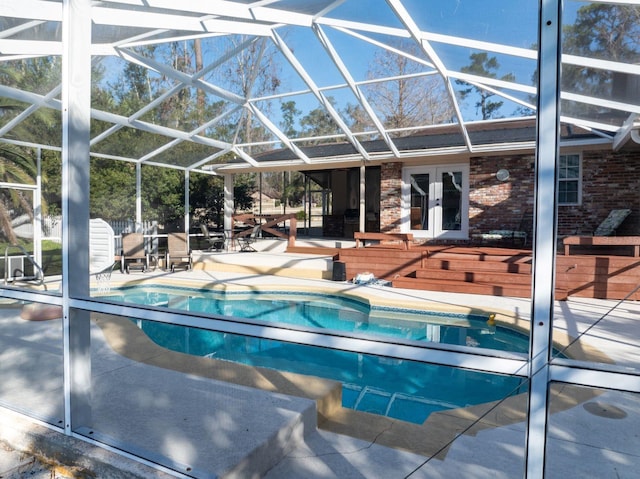 view of pool featuring a lanai, a patio area, and a hot tub