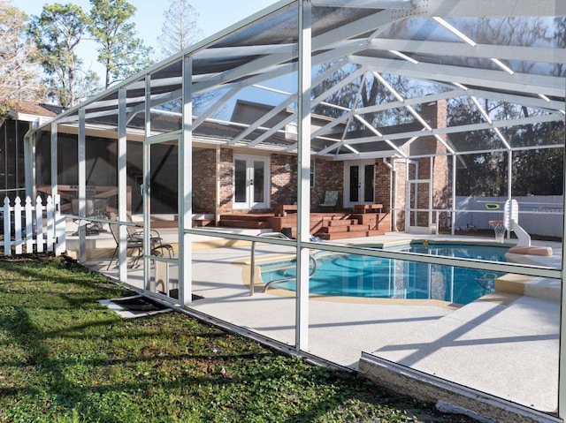 view of swimming pool with a patio, a lanai, and french doors