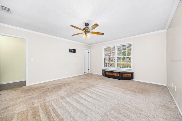 carpeted empty room featuring ornamental molding, ceiling fan, and a textured ceiling