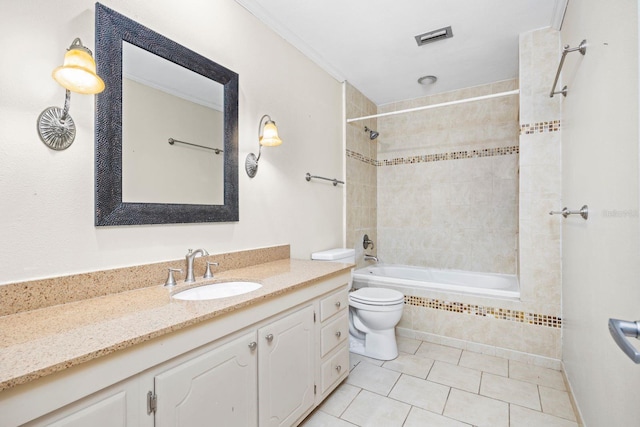 full bathroom featuring tiled shower / bath combo, vanity, tile patterned flooring, and toilet