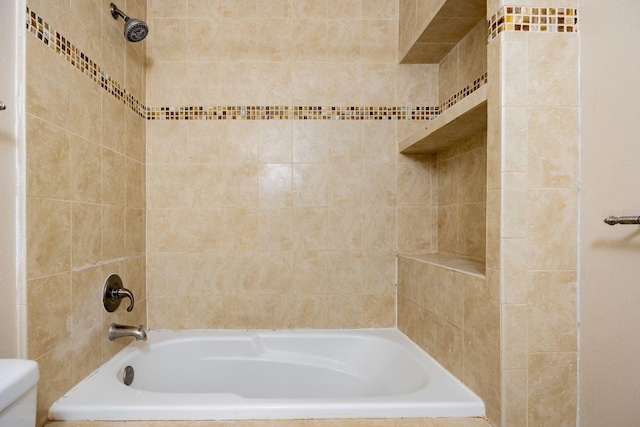 bathroom with tiled shower / bath and toilet