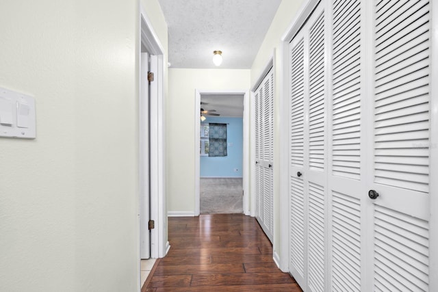 hall featuring dark hardwood / wood-style flooring and a textured ceiling