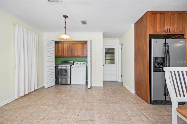 kitchen with pendant lighting, light tile patterned floors, crown molding, stainless steel fridge, and independent washer and dryer