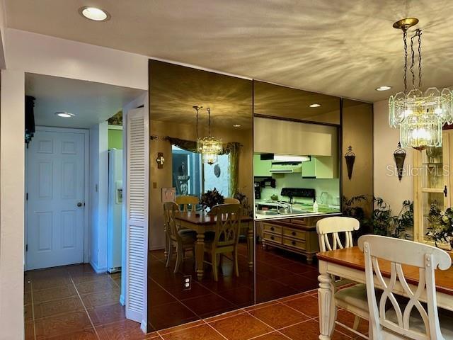 tiled dining room featuring an inviting chandelier