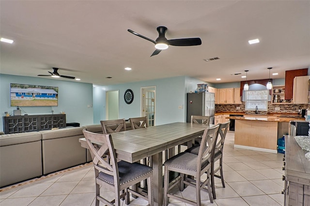 dining room with light tile patterned flooring, sink, and ceiling fan