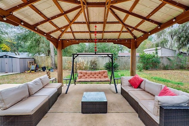 view of patio featuring a shed, an outdoor living space, and a gazebo