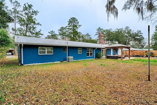 view of front of home featuring a patio area, a gazebo, central AC unit, outdoor lounge area, and a front yard