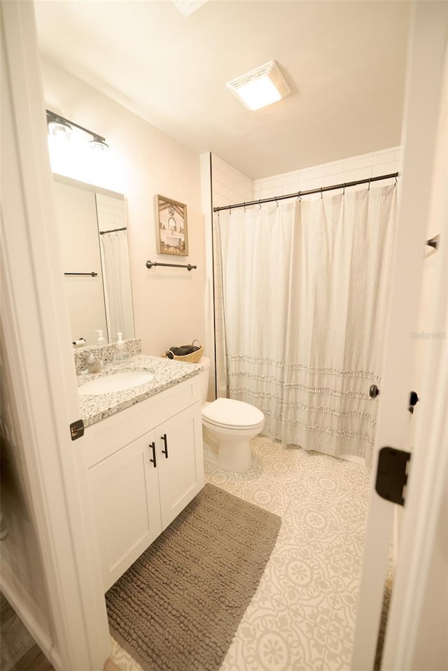 bathroom featuring tile patterned floors, vanity, and toilet