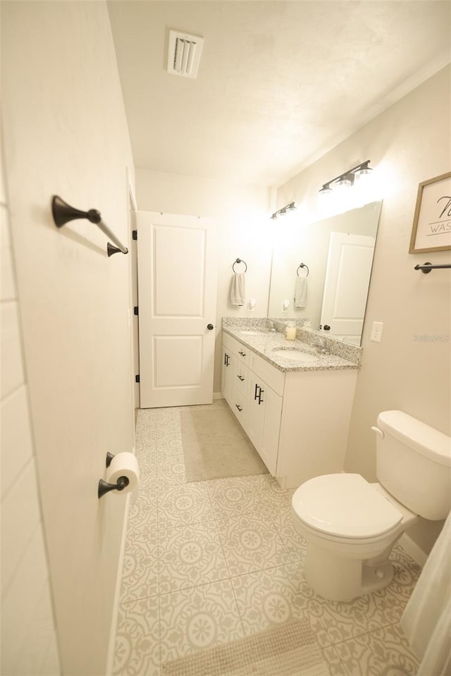 bathroom with tile patterned floors, vanity, and toilet