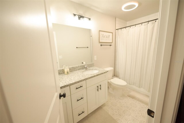 bathroom with a shower with curtain, tile patterned floors, vanity, and toilet