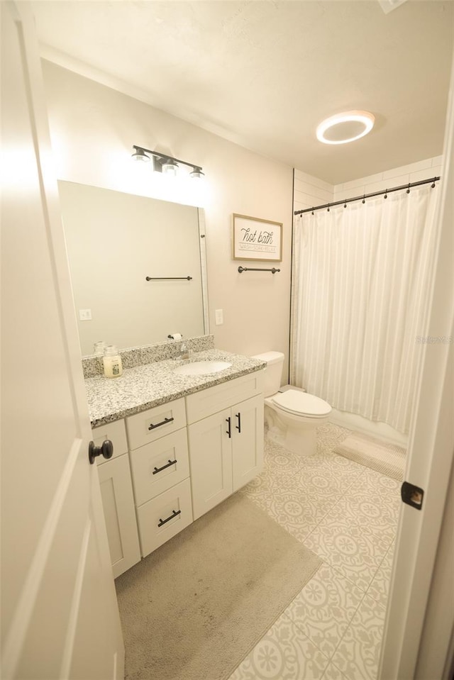 bathroom with tile patterned flooring, vanity, a shower with shower curtain, and toilet