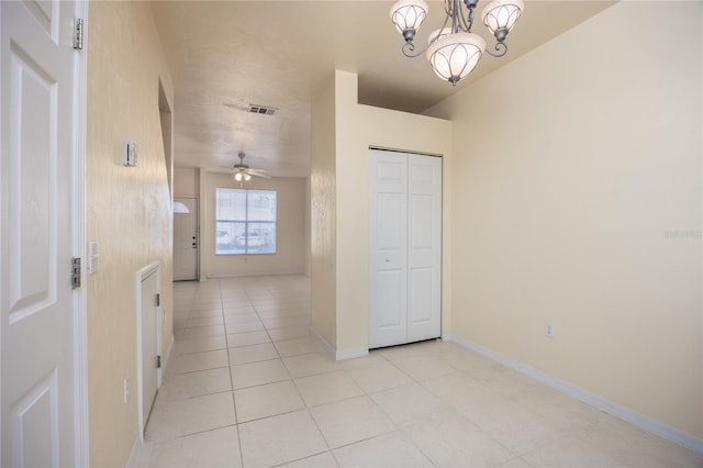 hallway featuring light tile patterned flooring and a notable chandelier