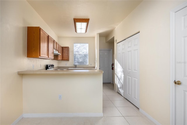 kitchen featuring sink, light tile patterned floors, kitchen peninsula, and stainless steel range oven