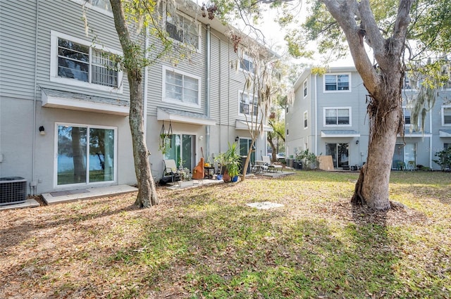 rear view of property featuring a yard and central AC