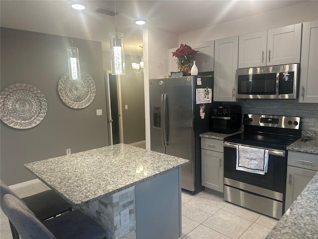 kitchen featuring a center island, light stone countertops, a breakfast bar, and appliances with stainless steel finishes