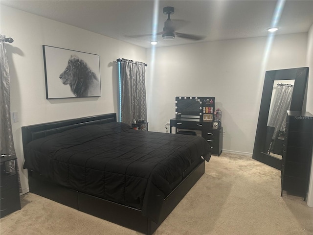 bedroom with ceiling fan and light carpet