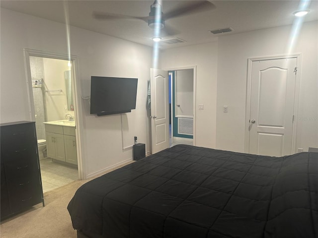 carpeted bedroom featuring ensuite bath and ceiling fan