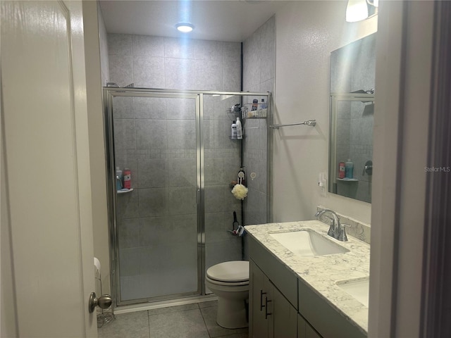 bathroom with tile patterned flooring, vanity, toilet, and walk in shower