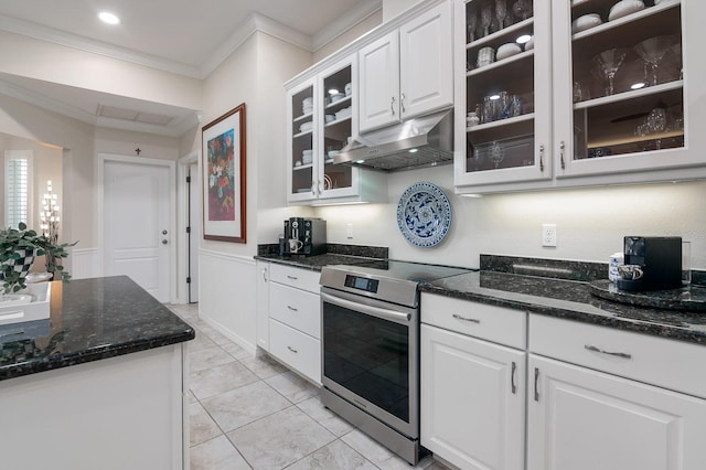 kitchen with dark stone countertops, white cabinets, stainless steel range with electric cooktop, ornamental molding, and light tile patterned floors