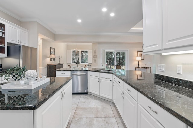 kitchen with stainless steel appliances, sink, dark stone counters, and white cabinets