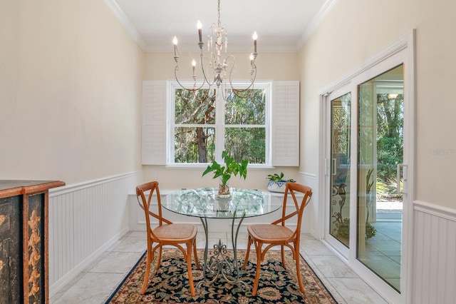 dining area with a notable chandelier, light tile patterned floors, and ornamental molding