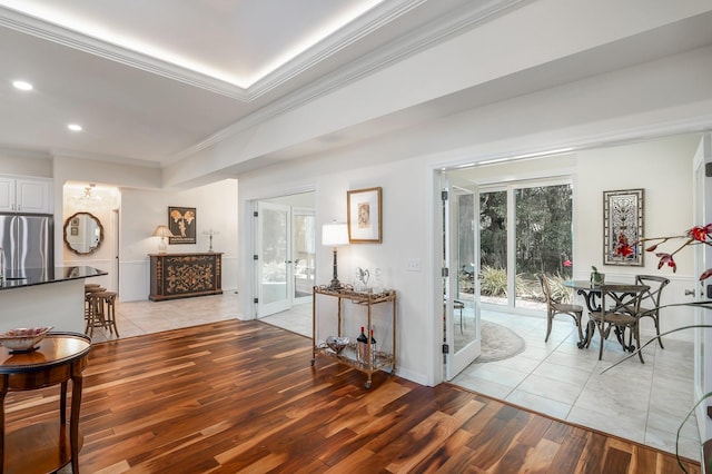 interior space featuring french doors, ornamental molding, and light hardwood / wood-style flooring