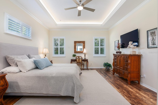 bedroom featuring ornamental molding, a tray ceiling, and dark hardwood / wood-style flooring