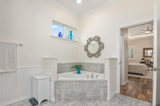 bathroom featuring tiled tub, hardwood / wood-style flooring, ornamental molding, and ceiling fan