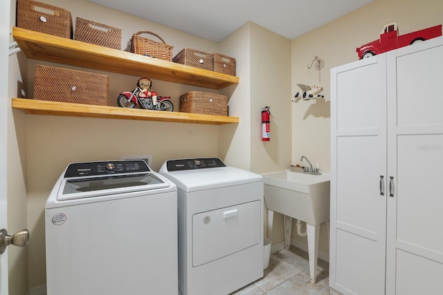 laundry room with cabinets, independent washer and dryer, and light tile patterned floors